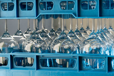 Blue plastic boxes with shiny wineglasses for restaurant standing upside-down and reflecting light