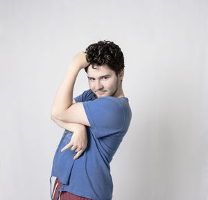 Portrait of young man standing against white background