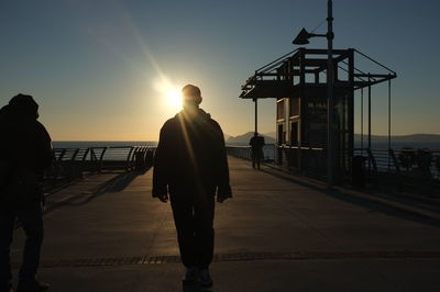 Silhouette of woman standing on landscape at sunset