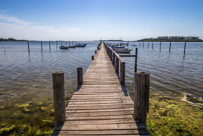 Wooden pier over lake against sky