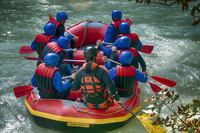 Rear view of men sitting on boat in sea