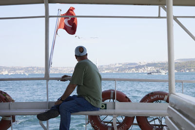 Rear view of man standing by sea