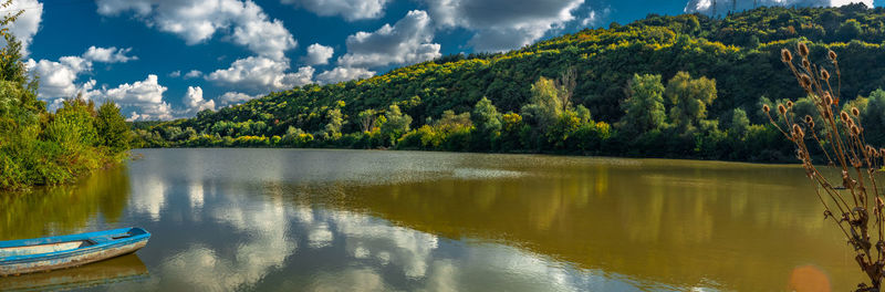 Scenic view of lake by trees against sky