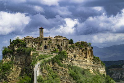 Low angle view of old ruins against cloudy sky