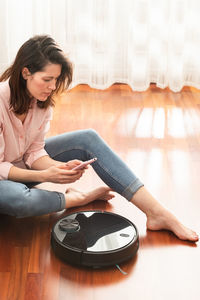 Young woman sitting on floor at home