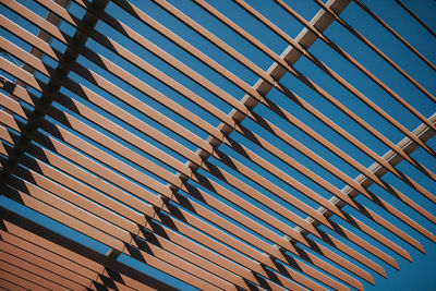 Low angle view of shade structure against clear blue sky