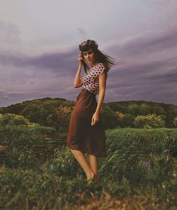 Full length of woman standing on field against sky