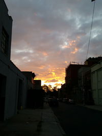 Houses against sky at sunset