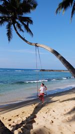 Scenic view of people on beach against sky