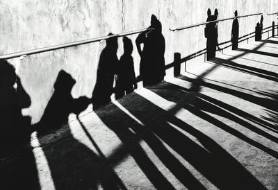 High angle view of people shadow on railing