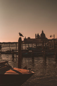 View of boats moored at canal during sunset