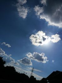 Low angle view of trees against blue sky