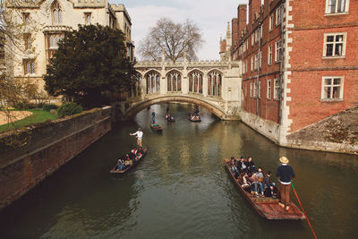 High angle view of people traveling in boat on canal amidst buildings