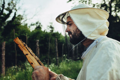 Midsection of man holding hat