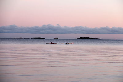 Boats in sea at sunset