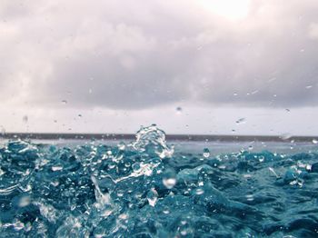 Close-up of water splashing against sky