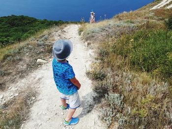 Rear view of boy walking on shore