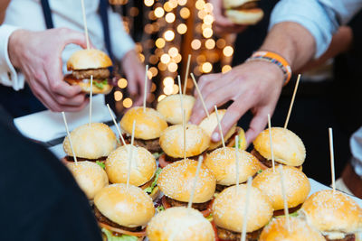 Cropped hands of people holding burgers