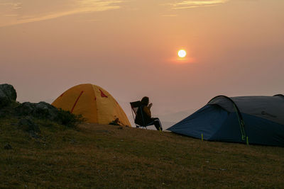 Tent on field against sky during sunset