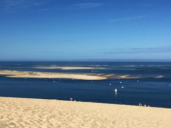 Scenic view of beach against blue sky
