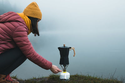 Rear view of woman drinking water against clear sky