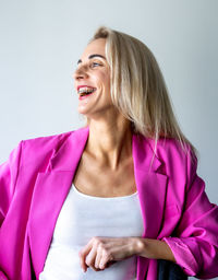 Portrait of smiling young woman against white background