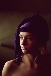 Close-up of thoughtful woman wearing purple headscarf