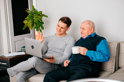 Grandfather and grandson doing video call on laptop