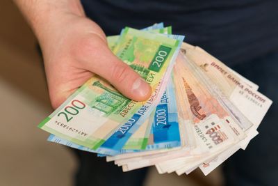 Midsection of man holding paper currencies