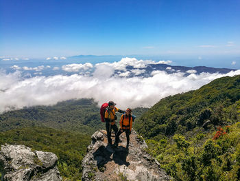 People on mountain against sky