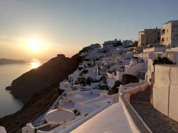 Panoramic view of sea and buildings against sky during sunset