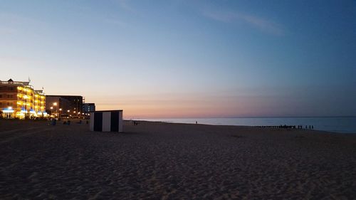 Scenic view of beach against clear sky during sunset