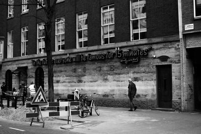 People sitting on bench against buildings in city