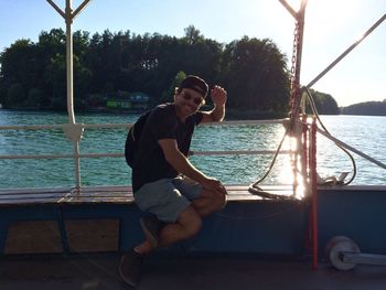 Young woman sitting on boat against sea