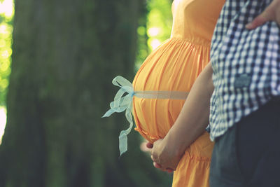 Midsection of pregnant woman standing with man