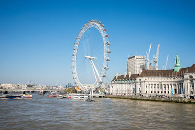 Ferris wheel in city against clear sky