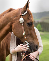 Close-up portrait of horse with woman in background