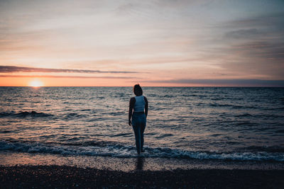 Rear view of woman standing on beach