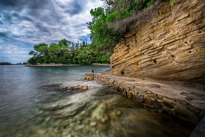 Rock formations by sea against sky