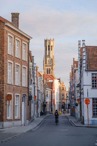 Road amidst buildings in city against sky