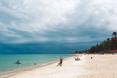 People on beach against sky