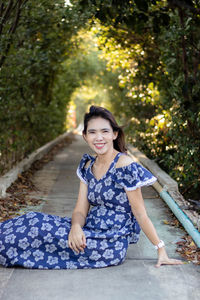 Portrait of young woman sitting in forest