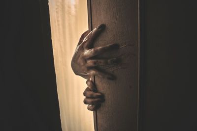 Close-up of hand against door