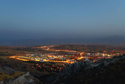 High angle view of illuminated cityscape against sky at night