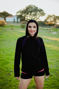 Portrait of smiling young woman standing on land