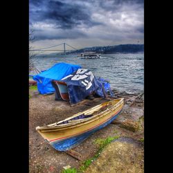 Boats in sea against cloudy sky