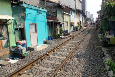 Railroad tracks amidst buildings in city