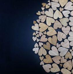 Close-up of stack of love wooden pieces on blue background 