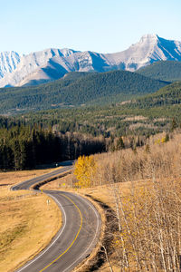 Road leading towards mountains against sky