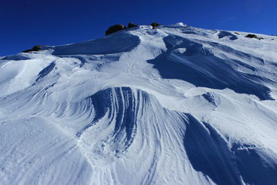 Snowcapped mountains against clear blue sky